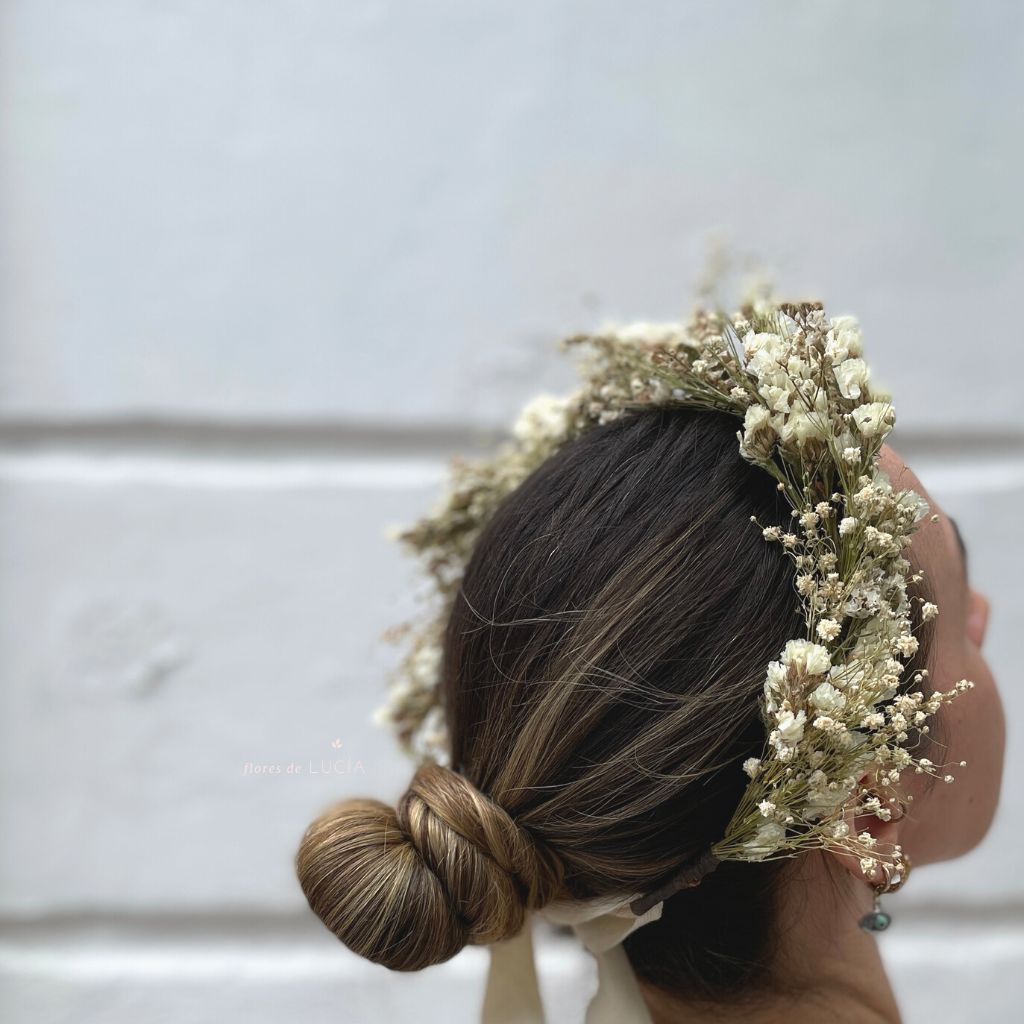 Diadema de flores secas color blanco ajustable a la cabeza.