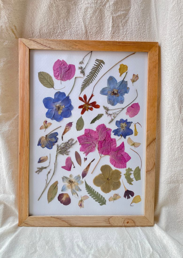 Cuadro de flores en colores del jardín, prensadas artesanalmente y enmarcadas en marco de madera natural y vidrio.