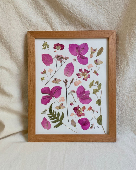 Cuadro de flores en tonos rozados, prensadas artesanalmente y enmarcadas en marco de madera nautral y vidrio.
